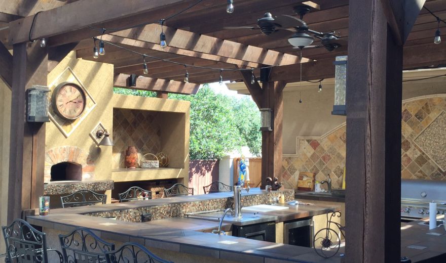A view of an outdoor kitchen with a wooden structure.