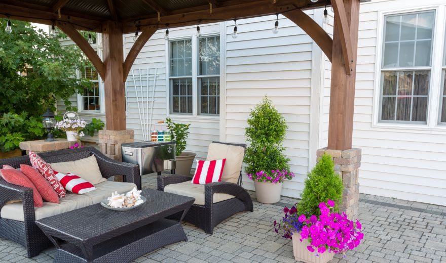 A patio with furniture and potted plants.